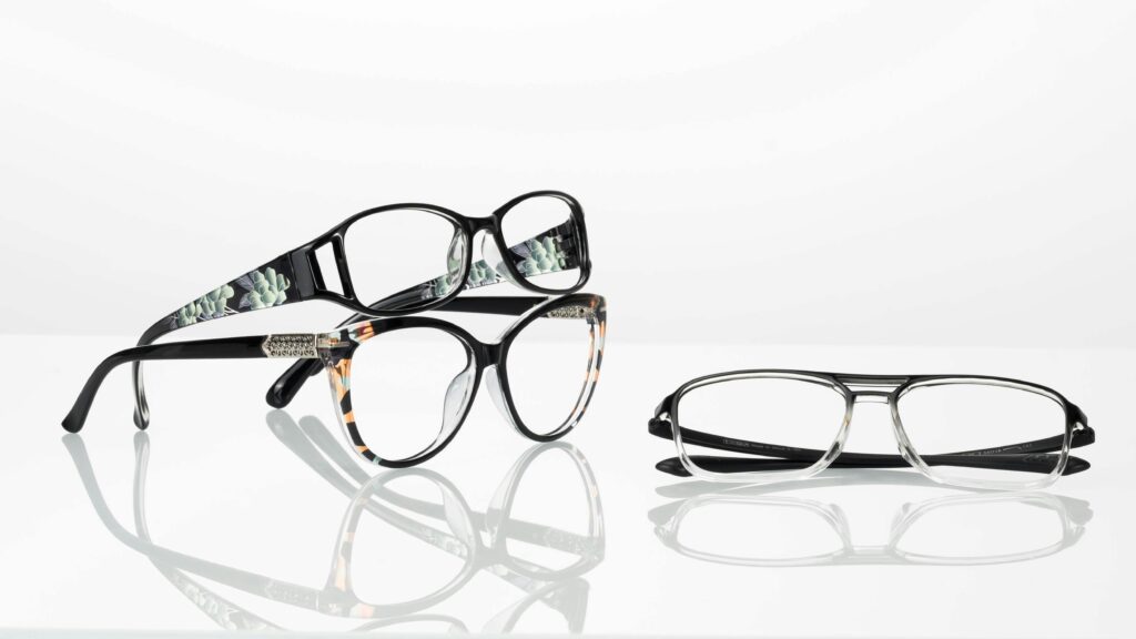 Elegant collection of modern glasses with stylish frames on a reflective surface.